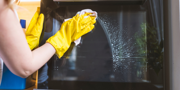 Professional cleaner deep cleaning oven door