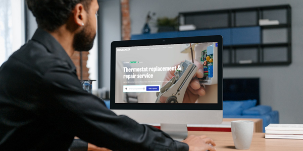 Man booking thermostat replacement on a computer