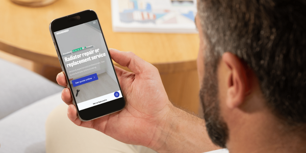 Man booking a plumber to replace a radiator on a smart phone