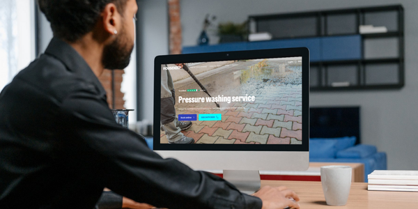 Man booking pressure washing services on a laptop through the Housekeep website