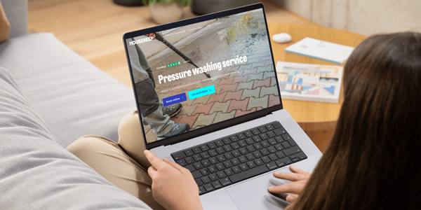 Women booking patio cleaning services through the Housekeep website on a laptop